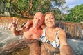 Senior happy couple taking selfie at Maquinit Hot Spring in Coron - Relax concept to Philippines wonders and active elderly