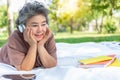 Senior happy woman listening music at park by wear headphone and using digital tablet Elderly woman get relax and happy when old Royalty Free Stock Photo