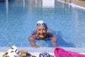 Senior happy woman with swim cap and swimming goggles smiling at the poolside enjoying the day of sports and swimming - active and Royalty Free Stock Photo