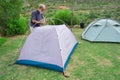 Senior hiker assembles tents on camping site