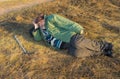 Senior hiker has short rest lying on the roadside at autumnal evening