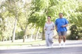 Senior Hispanic Couple Jogging In Park