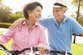 Senior Hispanic Couple Riding Bikes In Park Royalty Free Stock Photo