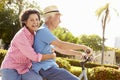 Senior Hispanic Couple Riding Bikes In Park Royalty Free Stock Photo