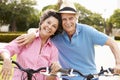 Senior Hispanic Couple Riding Bikes In Park Royalty Free Stock Photo