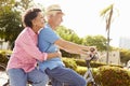 Senior Hispanic Couple Riding Bikes In Park Royalty Free Stock Photo