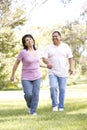 Senior Hispanic Couple Running In Park Royalty Free Stock Photo