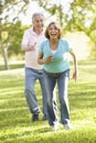 Senior Hispanic Couple Running In Park Royalty Free Stock Photo