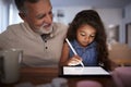 Senior Hispanic man with his young granddaughter using stylus and tablet computer, front, close up