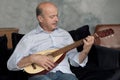 Senior hispanic man at home learning to play guitar.