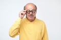 Senior hispanic man looking at camera wearing funny glasses Royalty Free Stock Photo