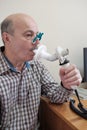 Senior hispanic man man testing breathing function by spirometry