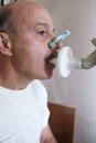 Senior hispanic man man testing breathing function by spirometry