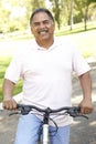 Senior Hispanic Man Riding Bike In Park Royalty Free Stock Photo