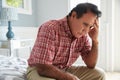 Senior Hispanic Man Sitting On Bed Suffering With Depression Royalty Free Stock Photo