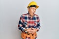 Senior hispanic man wearing handyman uniform with hand on stomach because indigestion, painful illness feeling unwell Royalty Free Stock Photo