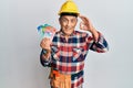 Senior hispanic man wearing handyman uniform and hardhat doing ok sign with fingers, smiling friendly gesturing excellent symbol Royalty Free Stock Photo