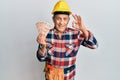 Senior hispanic man wearing handyman uniform holding turkish liras doing ok sign with fingers, smiling friendly gesturing Royalty Free Stock Photo