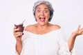 Senior hispanic woman drinking mate infusion celebrating achievement with happy smile and winner expression with raised hand Royalty Free Stock Photo