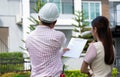 Senior home inspector explains Inspection results with homeowner, handyman holding clipboard and after checking details before