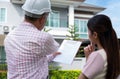 Senior home inspector explains Inspection results with homeowner, handyman holding clipboard and after checking details before