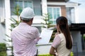 Senior home inspector explains Inspection results with homeowner, handyman holding clipboard and after checking details before