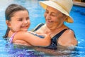 Senior hugging a child in the water