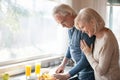 Senior husband cooking healthy breakfast for happy wife at home Royalty Free Stock Photo