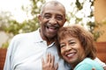 Senior husband and wife embracing, smiling to camera, close up