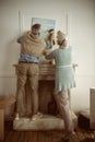 Senior husband and wife hanging picture on wall over the fireplace Royalty Free Stock Photo