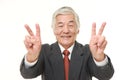 Senior Japanese businessman showing double victory sign Royalty Free Stock Photo