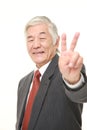 Senior Japanese businessman showing victory sign Royalty Free Stock Photo