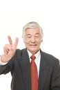 Senior Japanese businessman showing victory sign Royalty Free Stock Photo