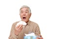 Senior Japanese man with an allergy sneezing into tissue Royalty Free Stock Photo