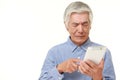 Senior Japanese man using tablet computer looking confused Royalty Free Stock Photo