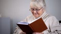 Senior lady eyeglasses reading book, pension leisure, free time hobby, education Royalty Free Stock Photo