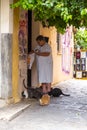 Senior lady feeding the street cats in the narrow streets of Plaka district in Athens