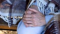 Senior lady hands, pensioner covered in blanket sitting on bench, rehab center