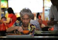 Senior lady having a meal in a hawkers center