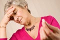 Senior lady with headache holding tablet or pill Royalty Free Stock Photo