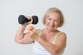 Senior lady holding a dumbbell and egg Royalty Free Stock Photo