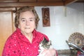 Senior lady holding her cat at home