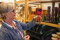 The senior lady in the home improvement store looks with interest at the two-tone hourglass. Many curious objects displayed around