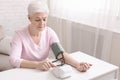 Senior lady with hypertension measuring blood pressure herself