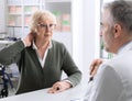 Senior lady with neck pain in the doctor`s office Royalty Free Stock Photo