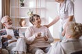 Senior lady with nurse and sitting with her elderly friends Royalty Free Stock Photo
