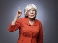 Senior lady points finger up Royalty Free Stock Photo