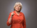 Senior lady points finger up Royalty Free Stock Photo