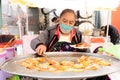 Senior lady prepares chalupas poblanas submerged in lard