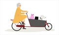 Senior lady riding cargo bicycle bakfiets with her pets cat and dog aboard. Elderly cyclist woman in elegant clothing.